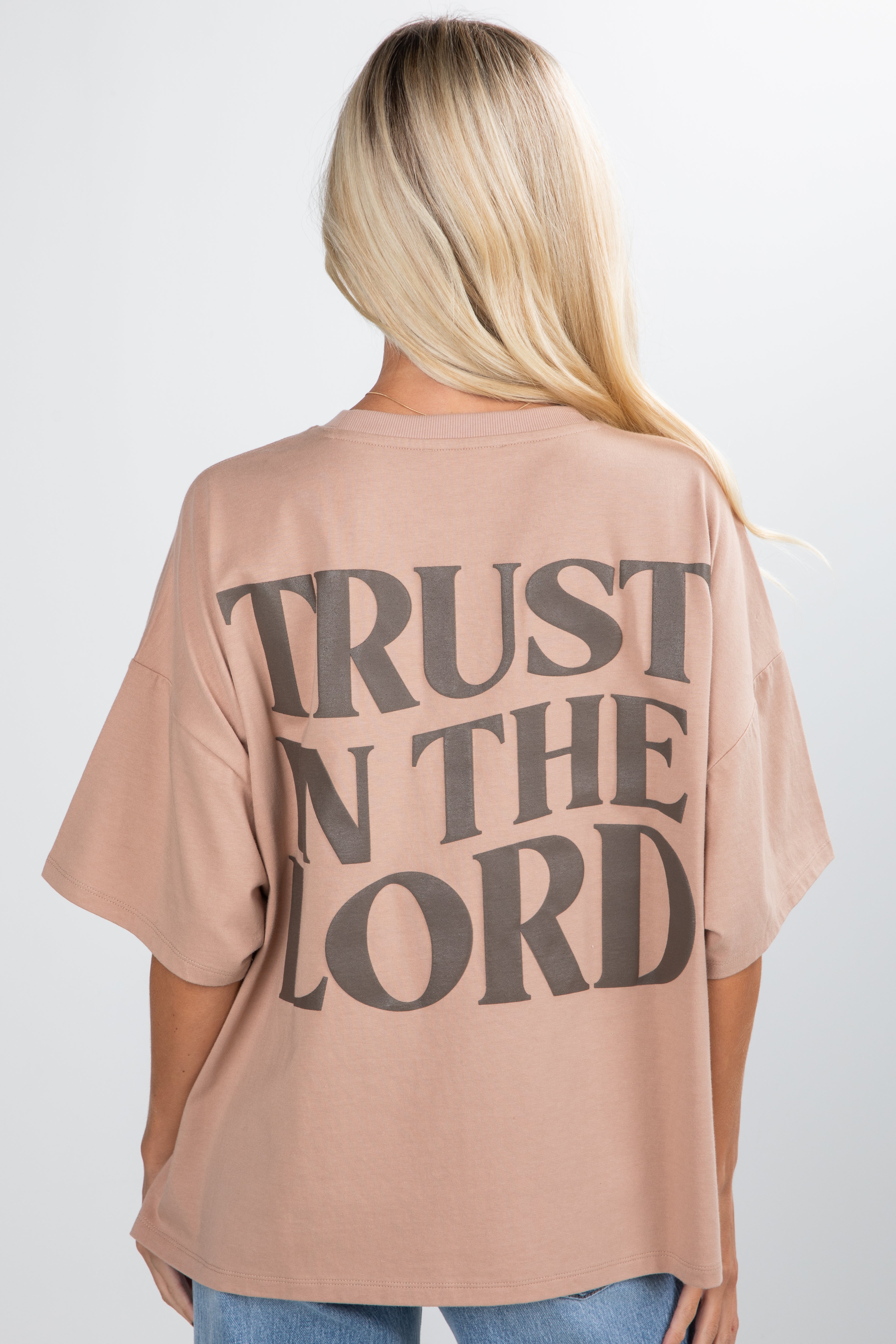 Person wearing a beige t-shirt with &