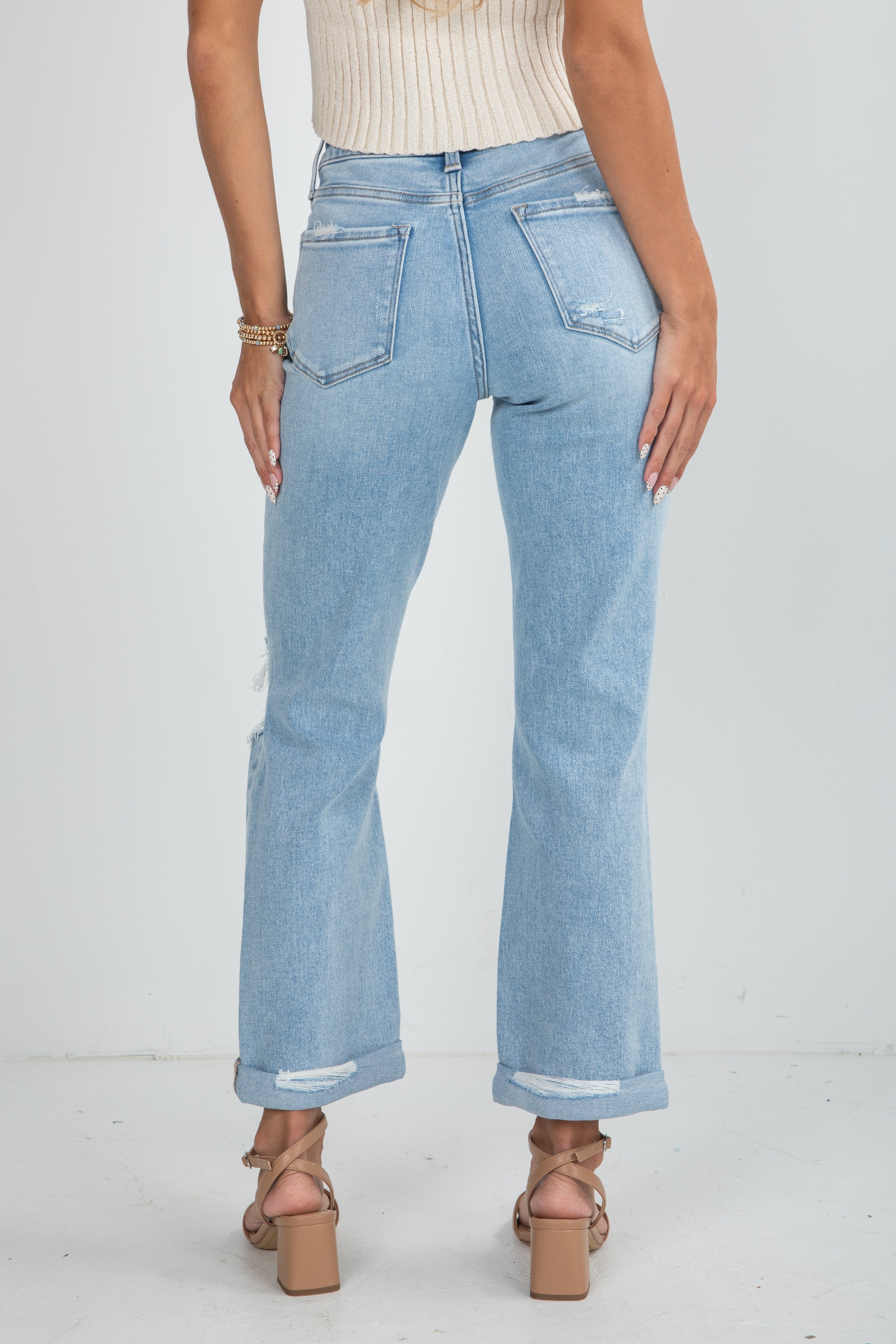 Light blue jeans worn by a person on a white background