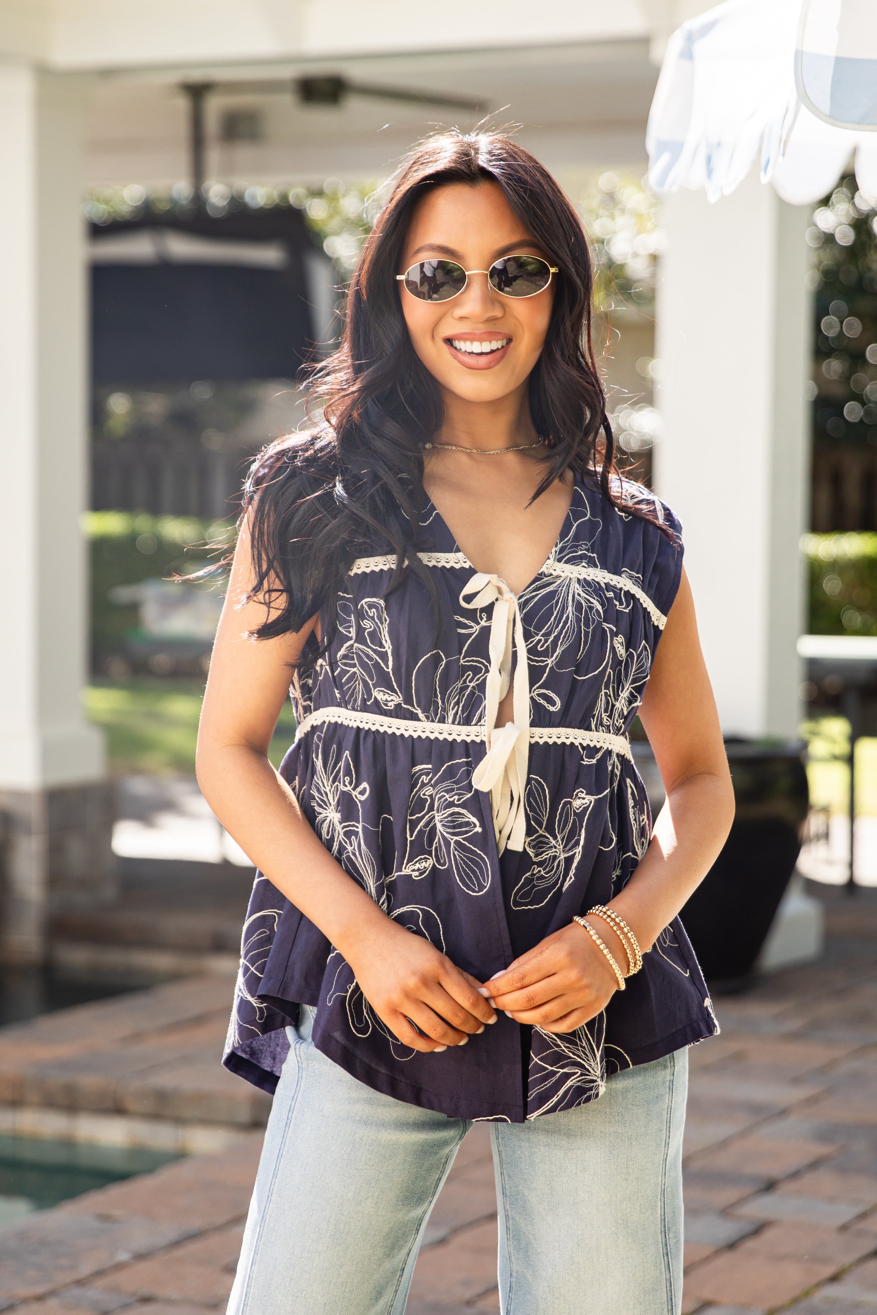 Woman wearing a patterned top and sunglasses outdoors