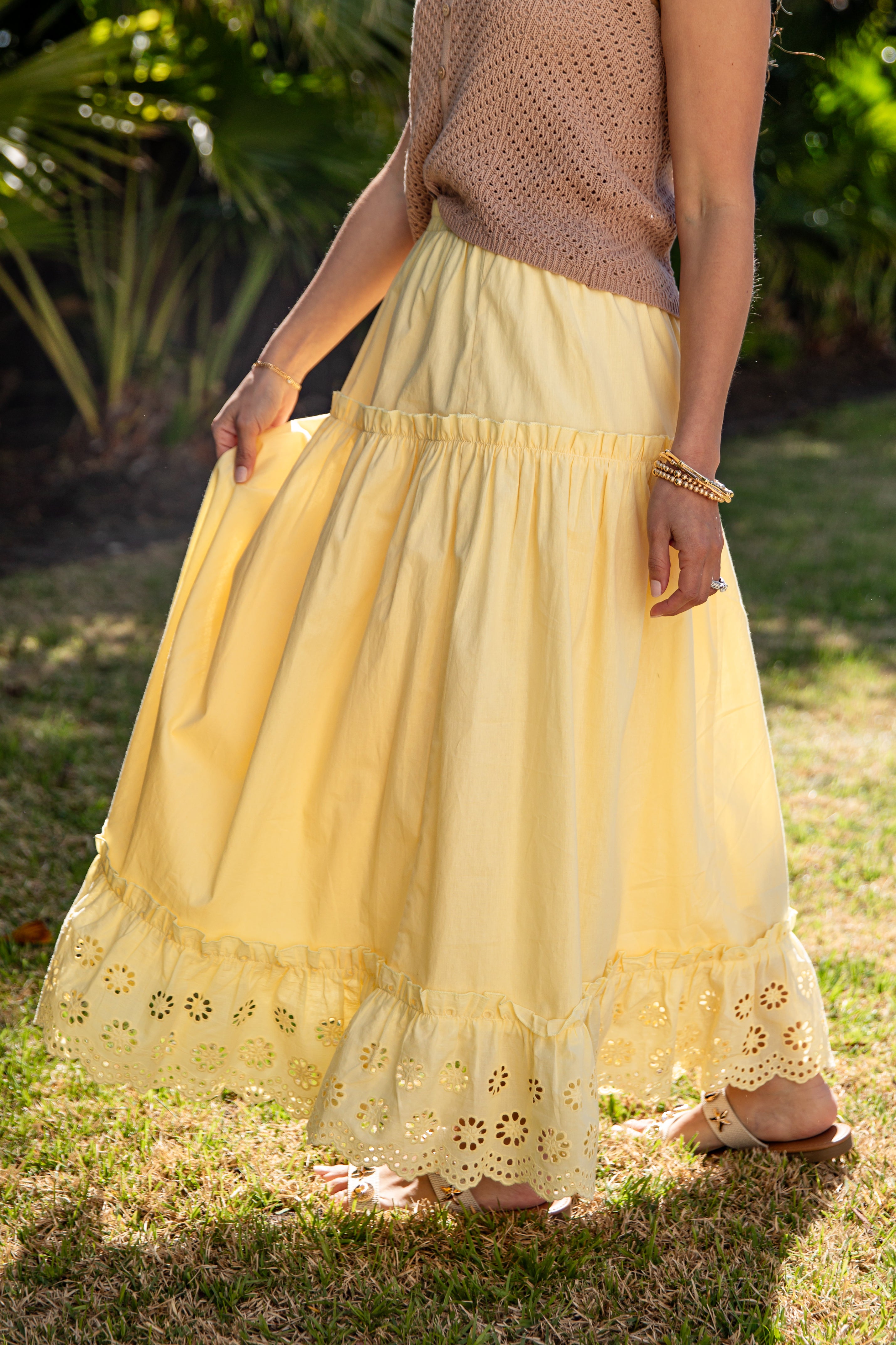 Person wearing a yellow lace-trimmed skirt outdoors