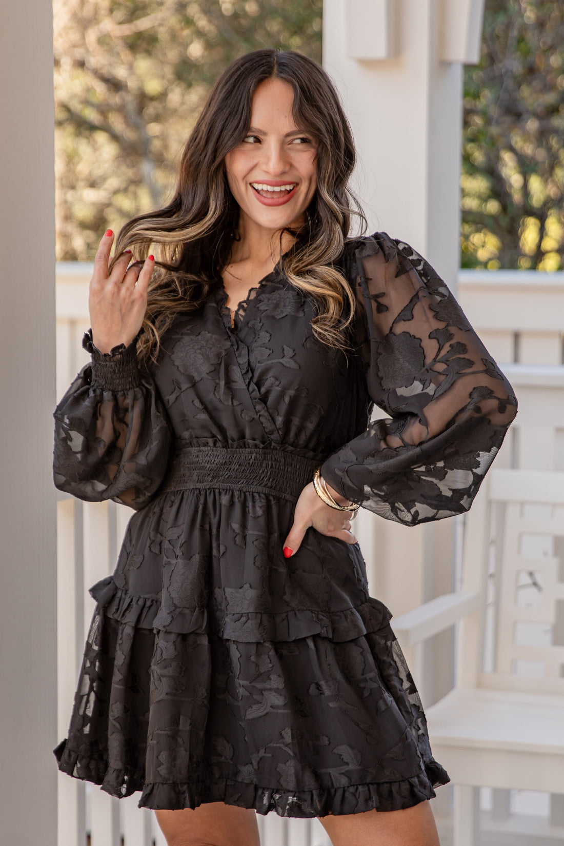 Woman wearing a black lace dress on a porch