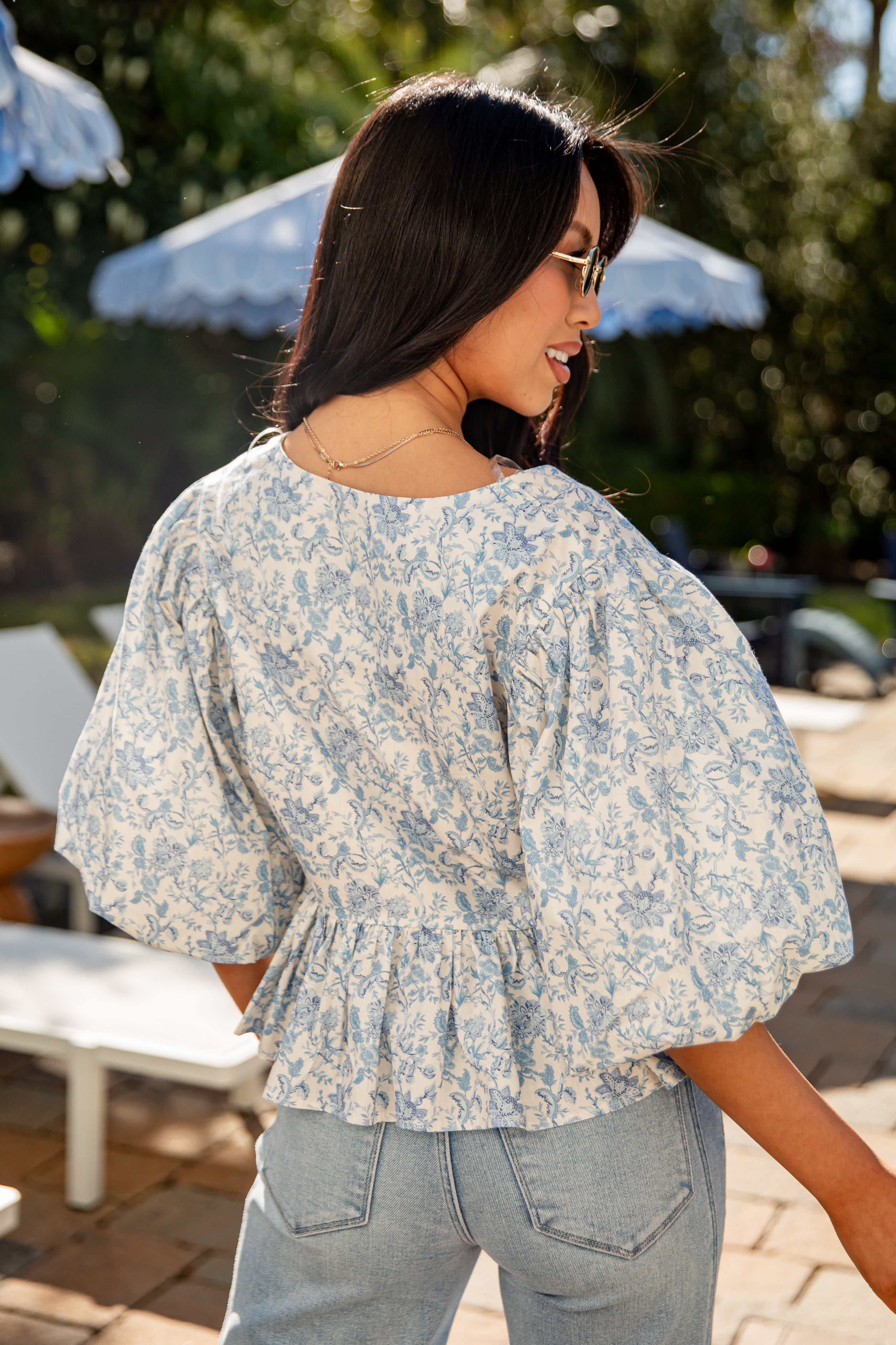 Woman wearing a floral blouse in an outdoor setting
