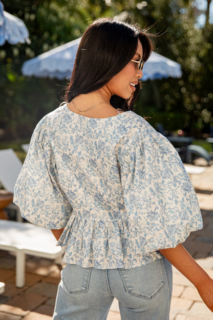 Woman wearing a floral blouse in an outdoor setting