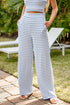 Person wearing a blue and white striped outfit standing outdoors with greenery in the background