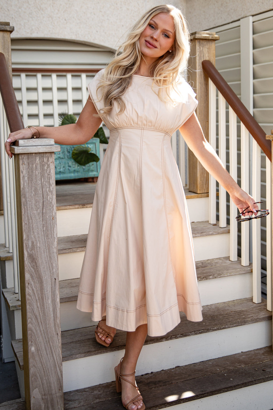 Woman in a white dress standing on a staircase