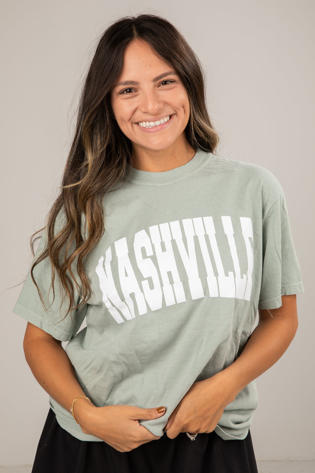 Woman wearing a green t-shirt with &