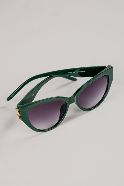 Green sunglasses with dark lenses on a light gray background