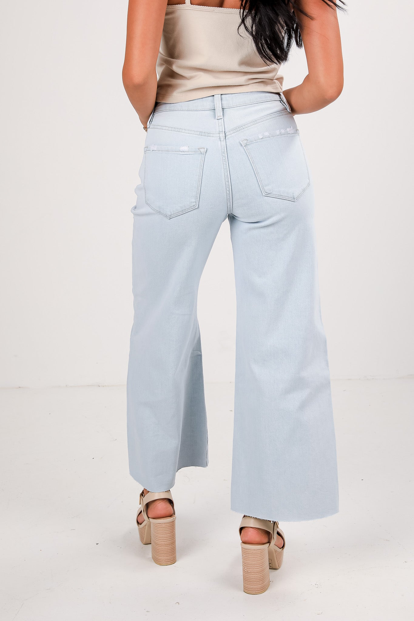 Light blue jeans worn by a person on a white background