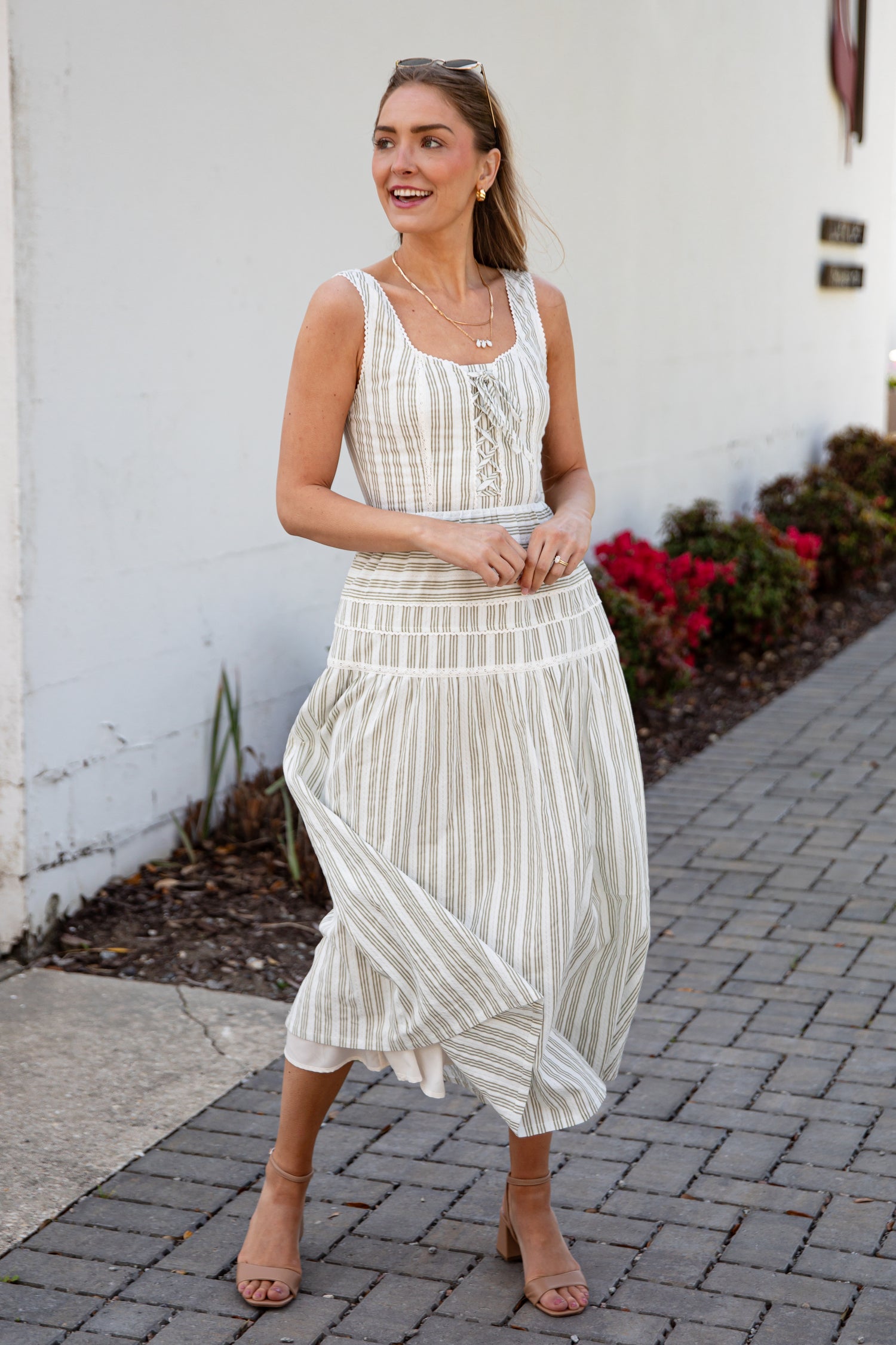 Woman wearing a spring striped maxi dress with sunglasses and nude heels