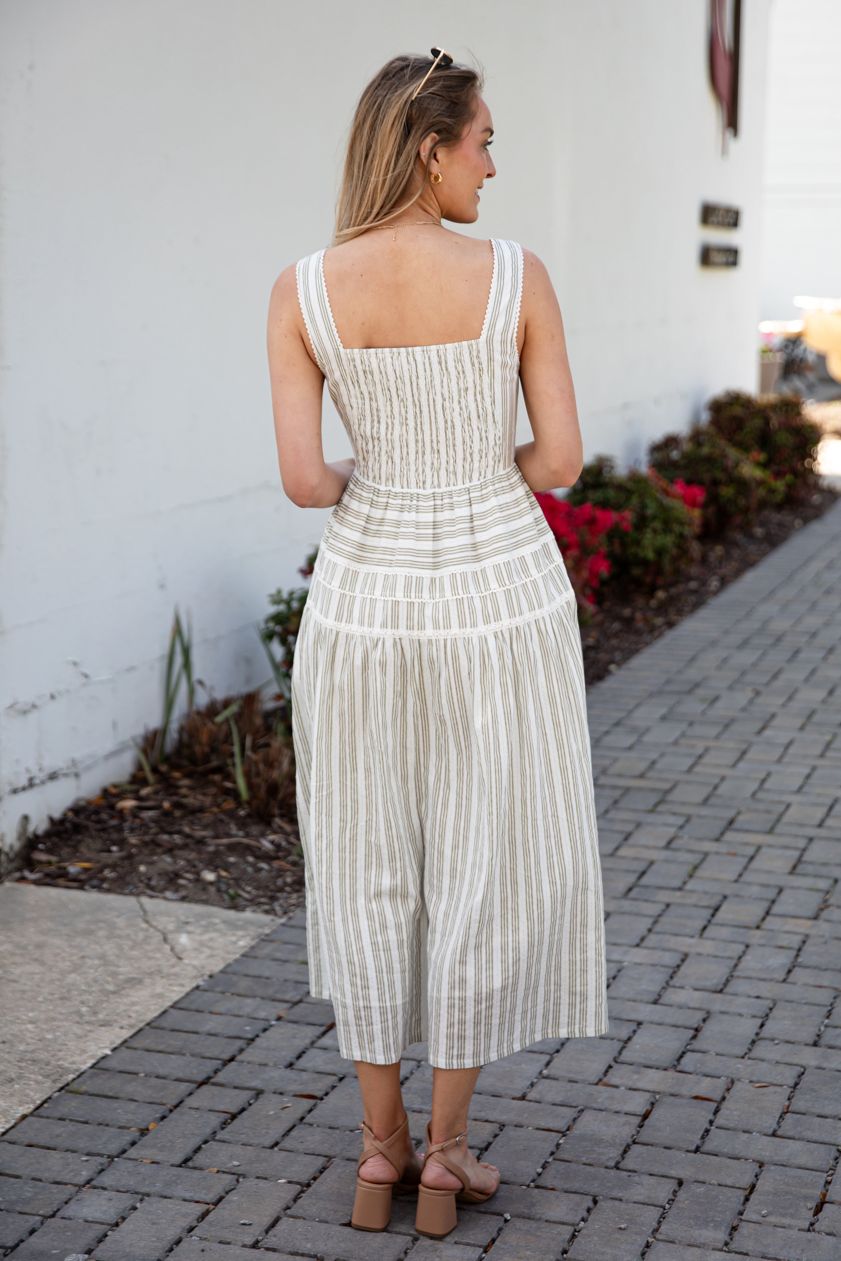Woman wearing a spring striped maxi dress with sunglasses and nude heels
